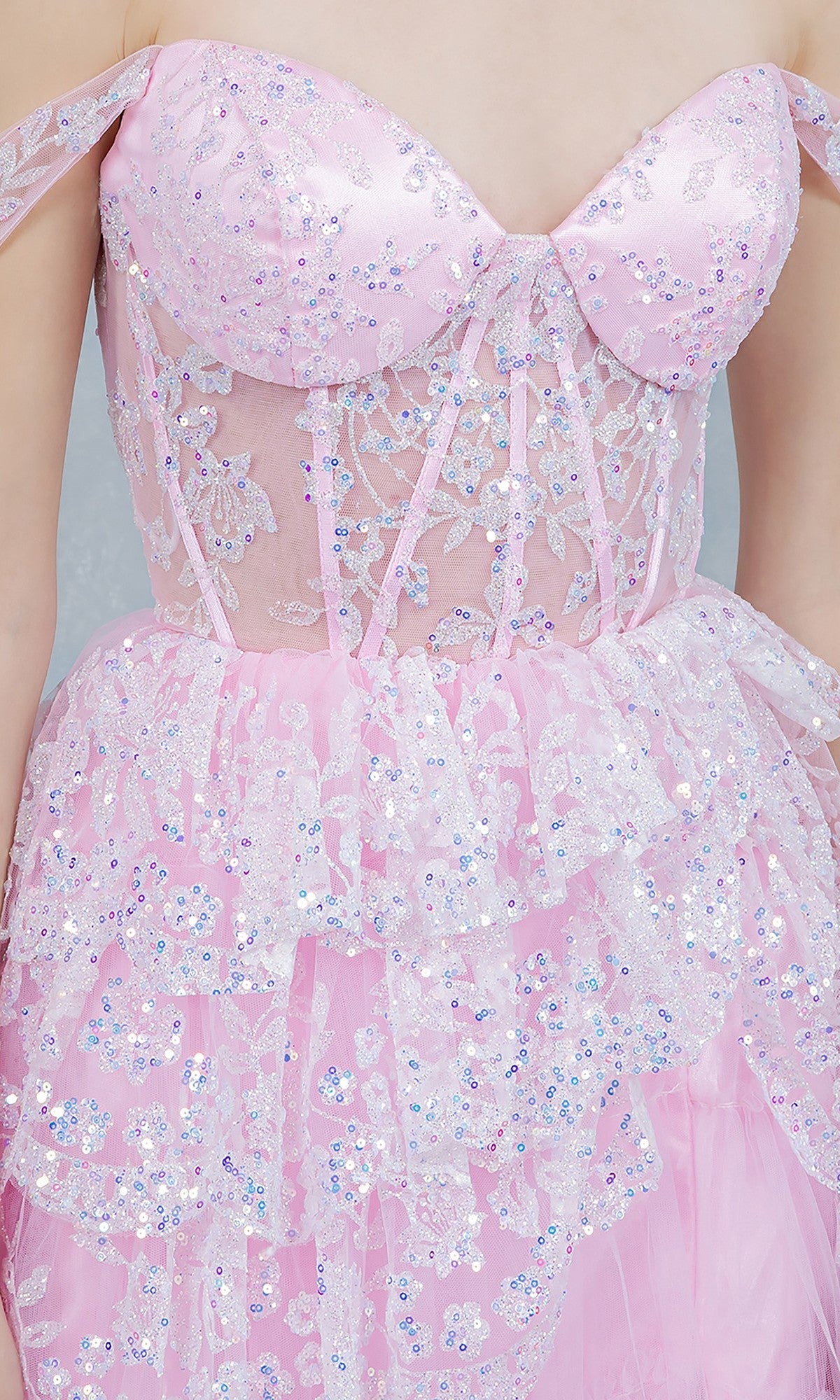 Close-up of a person wearing the Cinderella Couture 8499J, a long prom dress with sequin and floral lace details, a sheer corset bodice, and a layered tulle skirt.
